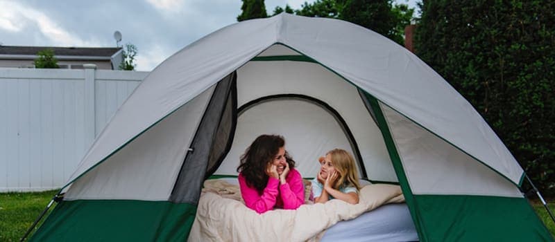 Mother and daughter camping in the backyard