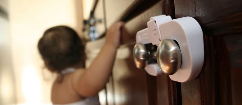 Baby trying to open a childproof cabinet