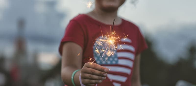 Child holding a sparkler on 4th of July