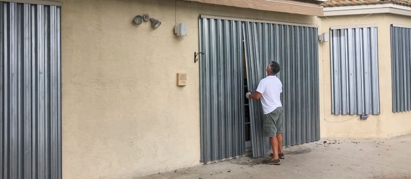Man covering windows before hurricane