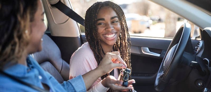 Mom handing her daughter the car keys