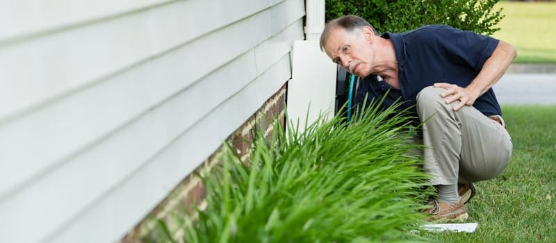 Man inspecting his home foundation
