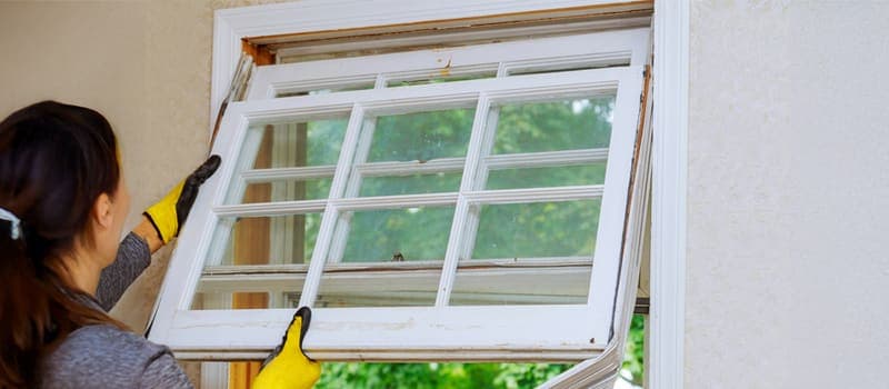 Woman replacing a window